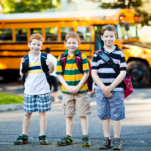 3 ginger boys in front of school bus